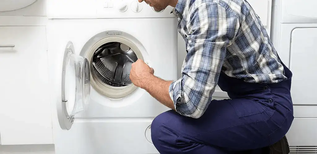 Handyman inspecting a dryer drum and internal parts for repair in Duluth, MN
