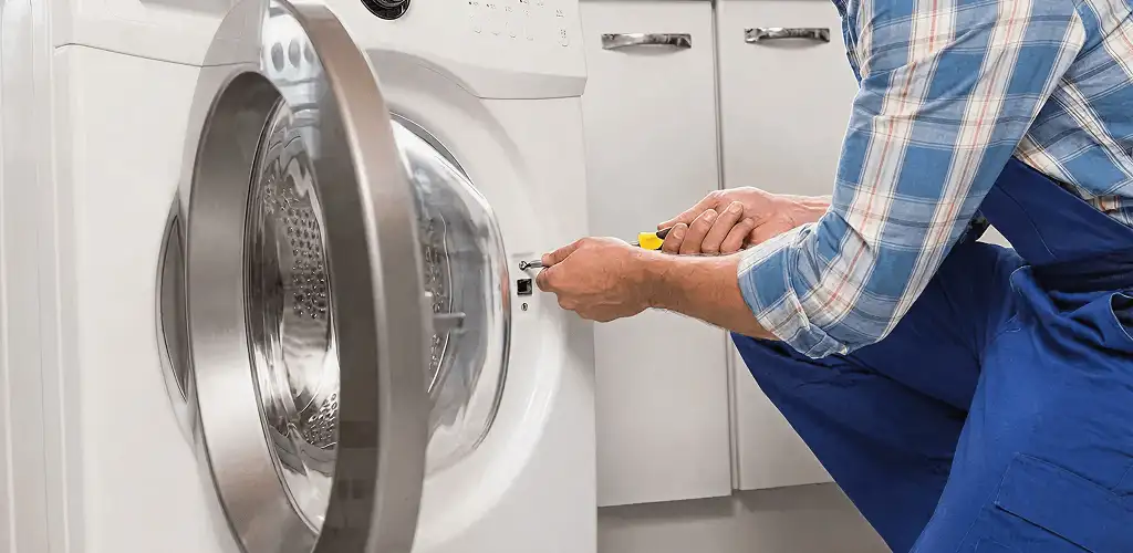 Handyman repairing a clothes dryer and checking electrical connections in Duluth, MN