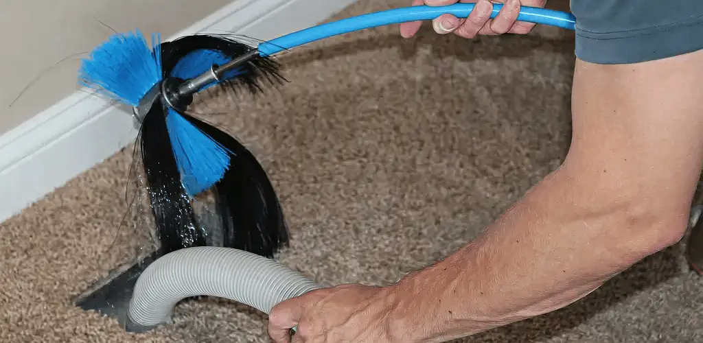 Dryer vent cleaning technician brushing lint from a vent line in Duluth, MN