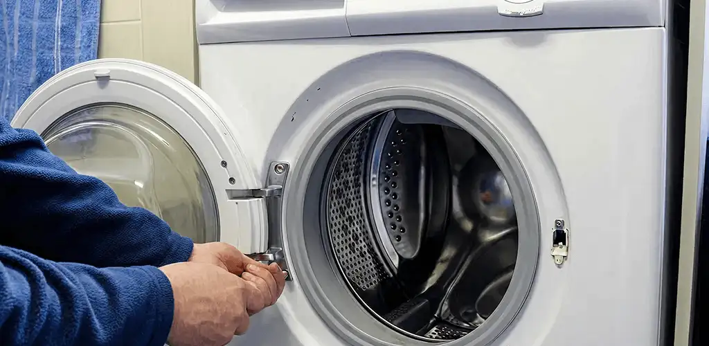 Washing machine repair handyman checking a front-load washer door and latch in Duluth, MN