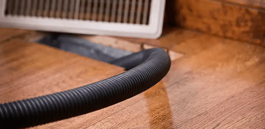 Air duct cleaning hose inserted into a floor vent for ductwork cleaning in Duluth, MN