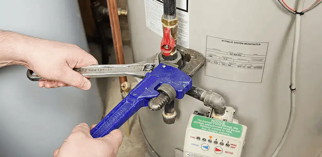 Water heater repair technician tightening the shutoff valve and supply line in Duluth, MN